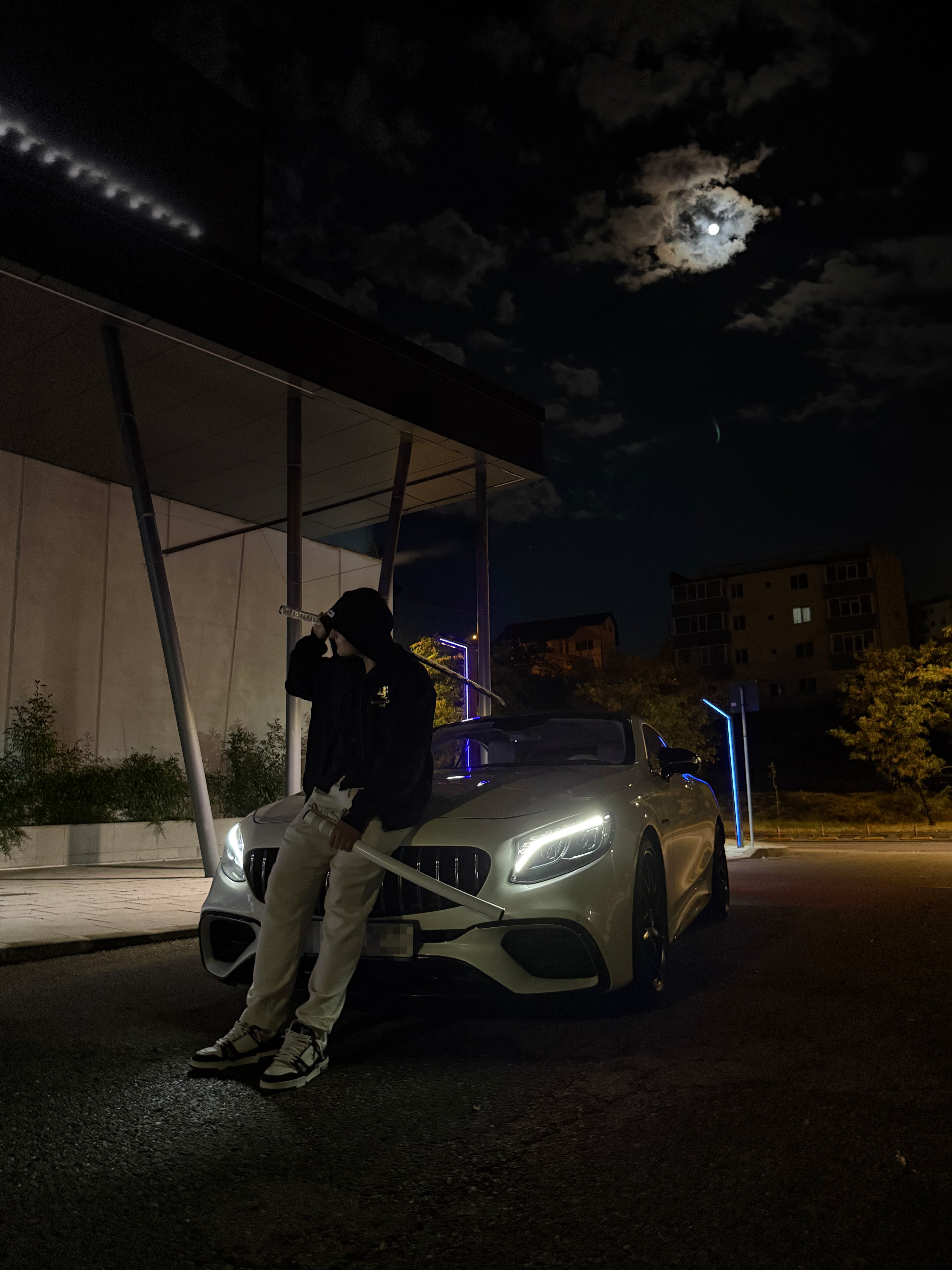 The founder of DEDI MOTION standing in front of a car at night.